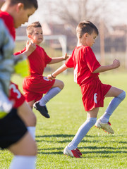 Obraz premium Kids soccer football - children players exercising before match on soccer field