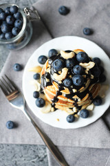 Stack of pancakes with blueberries and chocolate sauce. Top view.