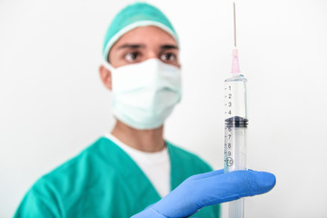 A  Doctor man with gloves holds a syringe