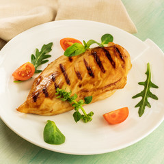 Grilled chicken fillet with cherry tomatoes and salad leaves