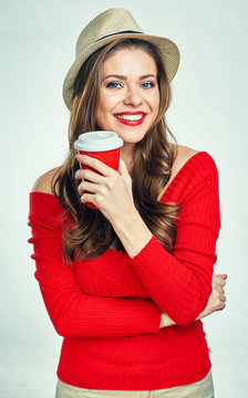 Beautiful smiling woman wearing red sweater holding red coffee cup.