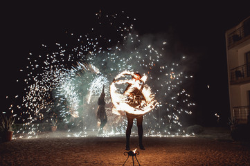 Fototapeta premium Fire dancing shows at night. Amazing fire show as part of wedding ceremony
