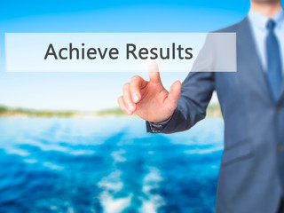ACHIEVE RESULTS - Businessman hand pressing button on touch screen interface.