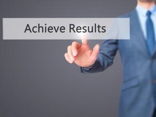ACHIEVE RESULTS - Businessman hand pressing button on touch screen interface.