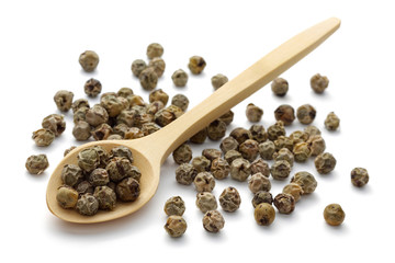 Green peppercorns in a wooden spoon