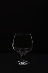 empty glass for cognac or whiskey isolated on black background