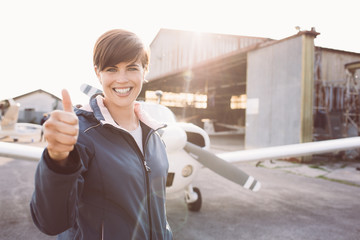 Cheerful young pilot giving a thumbs up