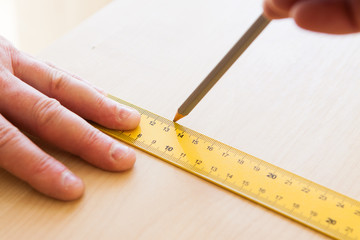 Man draws a pencil with ruler