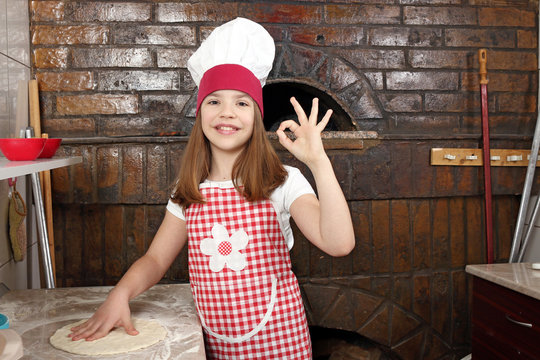happy little girl cook in pizzeria