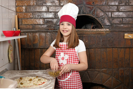 happy little girl cook real pizza in pizzeria