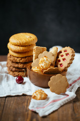 A set of crispy homemade biscuits with white napkin on wooden background. Natural concept. Copy space.