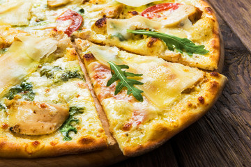 Delicious pizza with chicken, parmesan and fresh arugula