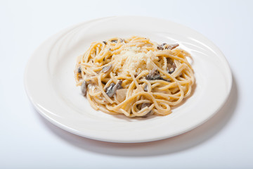 Italian pasta with mushrooms on a white plate