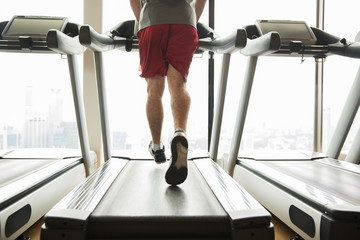 man exercising on treadmill in gym