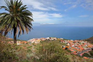 AGULO, LA GOMERA, SPAIN: General view of the village from a mountain trail with Teide volcano (Tenerife island) in the background