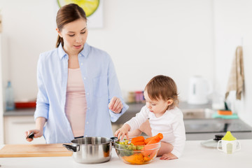 happy mother and baby cooking food at home kitchen