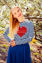 Young blond woman in blooming magnolia garden