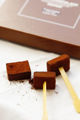 Square pieces of dark gourmet chocolate on rustic background