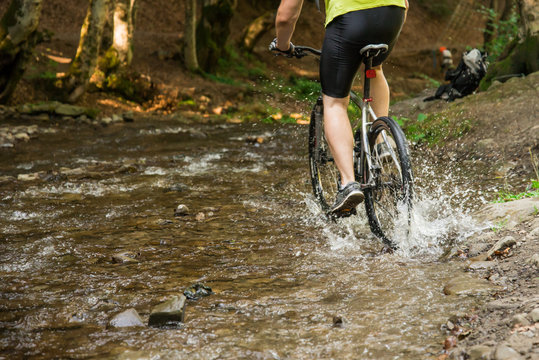 Mountain biker speeding through forest stream