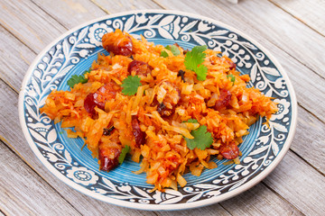 Cabbage with sausages, carrot, onion and tomato sauce
