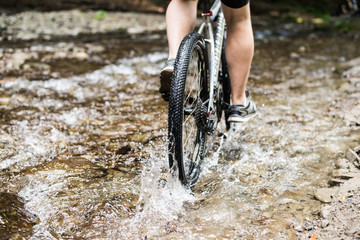 Mountain biker speeding through forest stream