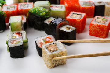 Set of sushi, maki and rolls isolated closeup with chopsticks