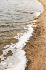 Bank of river with dirty foam