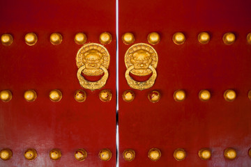 Chinese gate red doors with golden dragon heads knockers