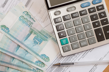 Calculator, utility bills and russian rubles on the table