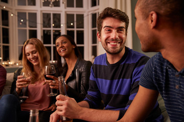 Group Of Friends With Drinks Enjoying House Party Together