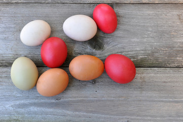 Traditional red Easter egg between different eggs on wooden background. Which egg is the best for painting