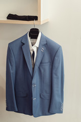 blue suit jacket with a white shirt on the rack