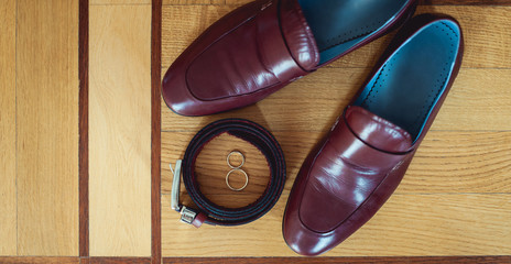 cherry men's shoes, belt and wedding rings in a box. groom's accessories at the wedding day