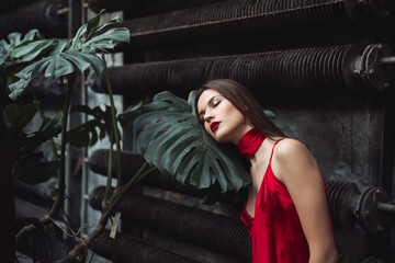 Woman sleeping on leaf of plant in greenhouse