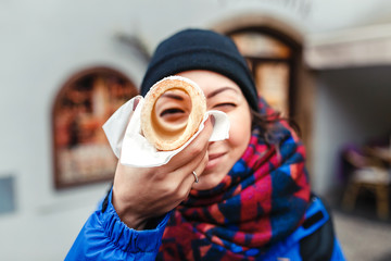 A woman with an appetite eats a traditional Czech sweet pastry called Trdelnik or Trdlo in Prague...