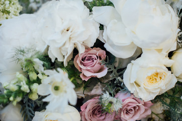 dinner decorated in the style boho for two with wood desk, a bouquet of white flowers and candlesticks