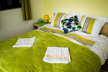 Interior of the bedroom in green colors. A large double bed is green.