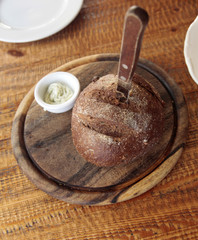 bread with bread knife on old wooden board