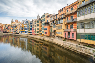 Cloudy view of riverside and bridge over river Onyar, Girona, Catalonia, Spain.