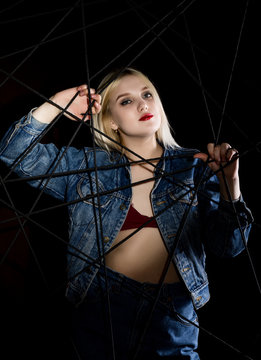 Fashion studio photo of young woman in danim jacket on dark background