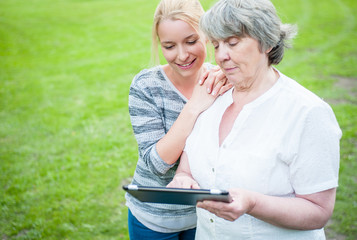 Young and old woman with tablet device