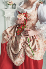 Beautiful woman in medieval dress holding pink rose