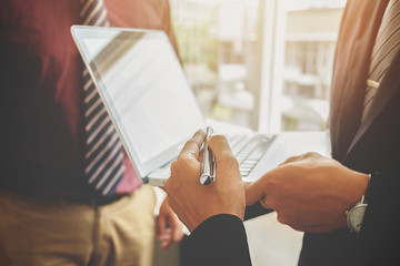 Business concept. Business people discussing the charts and graphs showing the results of their successful teamwork. Selective focus.