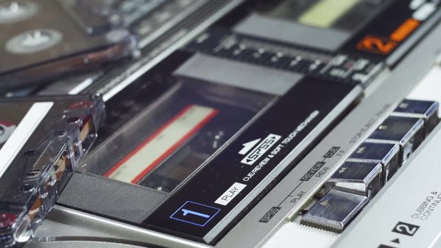 Audio Cassette Playing. Close-Up. Pushing a Finger Button Play, Stop on a Vintage Audio Cassette Player. Man finger presses playback control buttons.