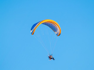 A man practicing extreme sport with paraglider with motor