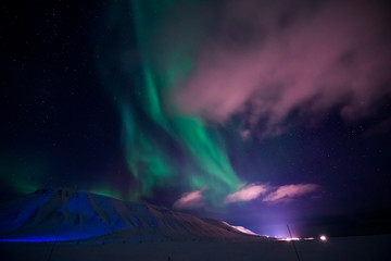 Fototapeta na wymiar The polar Northern lights in the mountains of Svalbard, Longyearbyen, Spitsbergen, Norway wallpaper