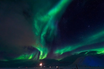 Fototapeta na wymiar The polar Northern lights in the mountains of Svalbard, Longyearbyen, Spitsbergen, Norway wallpaper