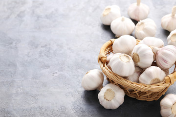 Garlic in basket on grey wooden table