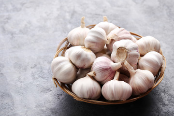 Garlic in basket on grey wooden table
