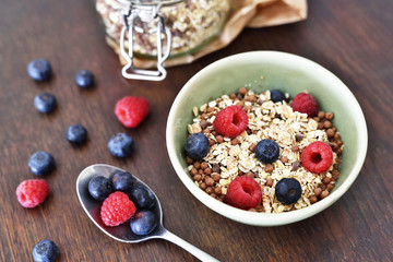 Breakfast bowl with fresh berry fruits. Cereals with blueberries and raspberries on a wooden table.